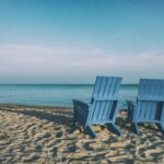Two beach chairs on a sandy shore
