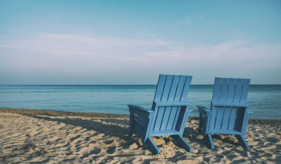 Two beach chairs on a sandy shore