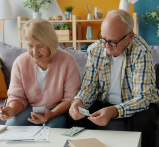 Retired couple filling out forms and counting money
